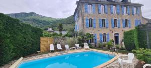a house with a swimming pool in front of a building at Gîte Le Layris in Campan