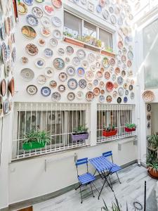 a wall of plates on a wall with two chairs at Jara Apartments ! in Málaga
