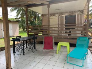 un patio con sillas coloridas y una mesa. en Yaoundé, en Rémire-Camp