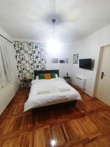 Schlafzimmer mit einem großen weißen Bett und Holzböden in der Unterkunft Top Secret in Aranđelovac