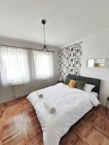 a large white bed in a bedroom with windows at Top Secret in Arandjelovac