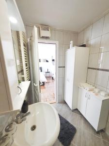 a white bathroom with a sink and a mirror at Top Secret in Arandjelovac