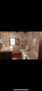 ein Badezimmer mit 2 WCs, einer Badewanne und einem Waschbecken in der Unterkunft CASAS RURALES MOLINO LA ERMITA in Zahara de la Sierra
