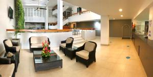 a lobby with chairs and a table and a counter at Hotel Be La Sierra in Santa Marta