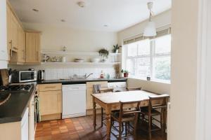 uma cozinha com uma mesa e algumas cadeiras em SUNNYSIDE APARTMENT - Spacious 2 Bedroom Ground Floor with Free Parking In Kendal, Cumbria em Kendal