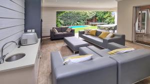 a living room with two couches and a sink at Cape Town Lock-and-Go House Ideal for your Holiday in Cape Town