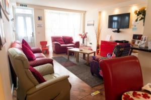 a living room with couches and chairs and a tv at The Old Bakery in Cromer