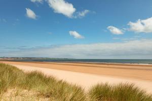 a beach with sand and the ocean on a sunny day at SEA VIEW - First Floor 3 bed apartment looking over Bridlington North Beach in Bridlington