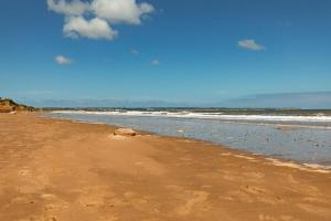 a sandy beach with the ocean in the background at SEA VIEW - First Floor 3 bed apartment looking over Bridlington North Beach in Bridlington +26 photos