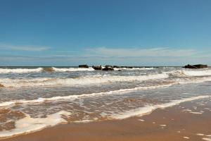 a beach with waves and rocks in the ocean at SEA VIEW - First Floor 3 bed apartment looking over Bridlington North Beach in Bridlington