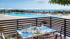 a table with plates of food on it next to a pool at Blue Jasmine Hotel in Skala