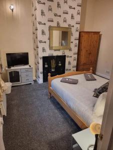 a bedroom with a bed and a tv and a mirror at Carlisle City Centre, Cute Victorian House. in Carlisle