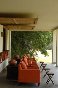 a living room with an orange couch and a large window at Mahua Kothi Bandhavgarh - A Taj Safari Lodge in Tāla