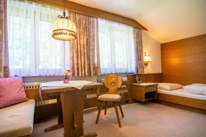 um quarto com uma secretária, uma cama e uma mesa em Köcks Bed & Breakfast em Galtür