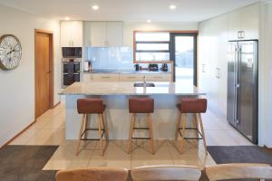 a kitchen with a large island with bar stools at Lake Lodge - Lake Tekapo in Lake Tekapo