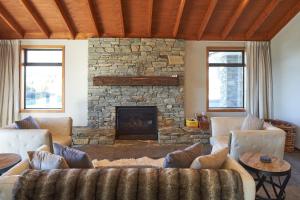 a living room with a couch and a stone fireplace at Lake Lodge - Lake Tekapo in Lake Tekapo