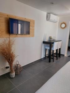a room with a table and a tv on a wall at La Micocoule in La Barben