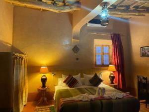 a bedroom with a bed and a lamp in it at Riad Paradise of Silence in Aït Benhaddou