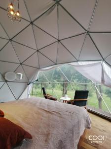 a bedroom in a tent with a bed and chairs at Cool Glamping La aventurosa in Toluca