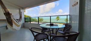 a balcony with a table and chairs and a view of the ocean at Flat Tabatinga Nord, vista para o mar in Conde