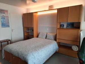- une petite chambre avec un lit et des placards en bois dans l'établissement Studio On The Beach With Sea View, à Middelkerke