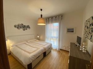 ein Schlafzimmer mit einem Bett und einem großen Fenster in der Unterkunft Alojamiento el Dorado in Llanes