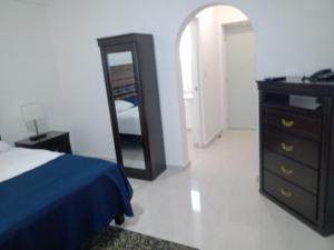 1 dormitorio con cama, tocador y espejo en Sierra 2, en Acapulco