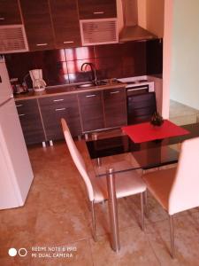 uma cozinha com uma mesa e cadeiras numa cozinha em La betia em Litochoro