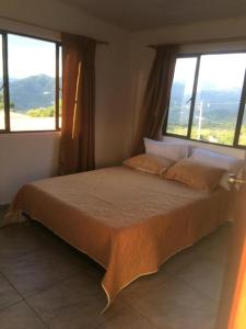 - une chambre avec un grand lit et 2 fenêtres dans l'établissement APARTAHOTEL TAYAMBE, à La Mesa