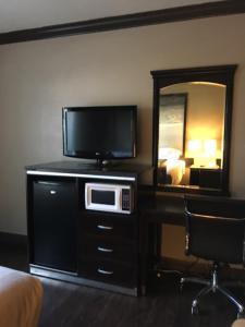 a hotel room with a television and a desk with a microwave at Skyways Hotel in Los Angeles