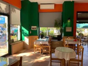 a restaurant with tables and chairs and a green wall at Stephen Center B&B in Tirana