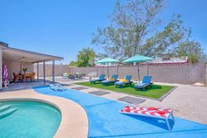 una piscina con tumbonas y sombrillas en Fab PHX Getaway w/ Pool & Fire Pit, en Phoenix