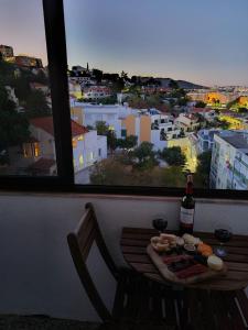 una mesa con una botella de vino junto a una ventana en City Centre Apartment Setubal, en Setúbal