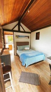 a bedroom with a bed and a wooden ceiling at Chalé de Pedras no Pontal do Atalaia in Arraial do Cabo