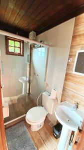 a bathroom with a toilet and a shower and a sink at Chalé de Pedras no Pontal do Atalaia in Arraial do Cabo