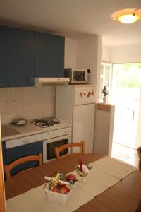 a kitchen with a table with a bowl of fruit on it at Apartman Miro in Cavtat