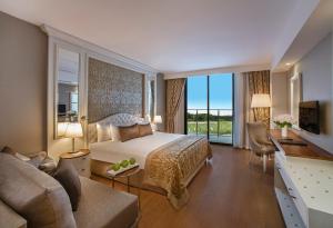 A bed or beds in a room at Aska Lara Resort & Spa Hotel