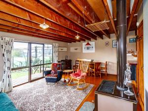 a living room with a fireplace and a table with chairs at Green Gables Raetihi - Ohakune Holiday Home in Raetihi