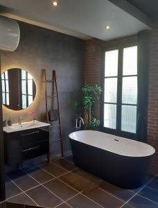 a large bathroom with a large tub and a sink at Le Studio Loft in Ancy-le-Franc +5 photos