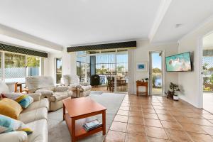 a living room with couches and a table at HALYCON HOUSE in Banksia Beach