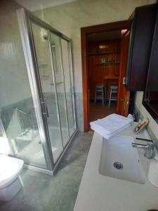 bagno con doccia in vetro e lavandino di GARDEN ROOMS a Castro-Urdiales