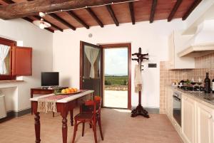 a kitchen with a table with a bowl of fruit on it at Agriturismo Il Poggione in Montalcino