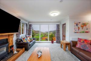 a living room with a couch and a large window at 5 bed house near Oban in Oban