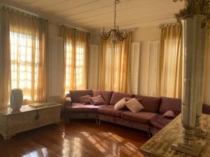 a living room with a brown couch and windows at Hotel Boutique Inconfidentes in Tiradentes