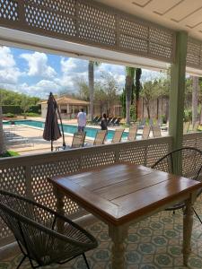 a wooden table and chairs on a patio with a pool at Hotel Boutique Inconfidentes in Tiradentes