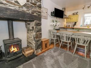 a living room with a fireplace and a stove at Snowdon View in Caernarfon