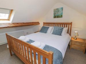 een slaapkamer met een groot houten bed met blauwe kussens bij Snowdon View in Caernarfon