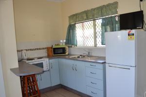 a kitchen with white appliances and a white refrigerator at Cooktown Motel in Cooktown