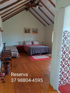 1 dormitorio con 1 cama y suelo de madera en Aldeia Canastra Pousada en São Roque de Minas