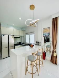 a white kitchen with a white counter and bar stools at KW pool villa pattaya in Pattaya Central